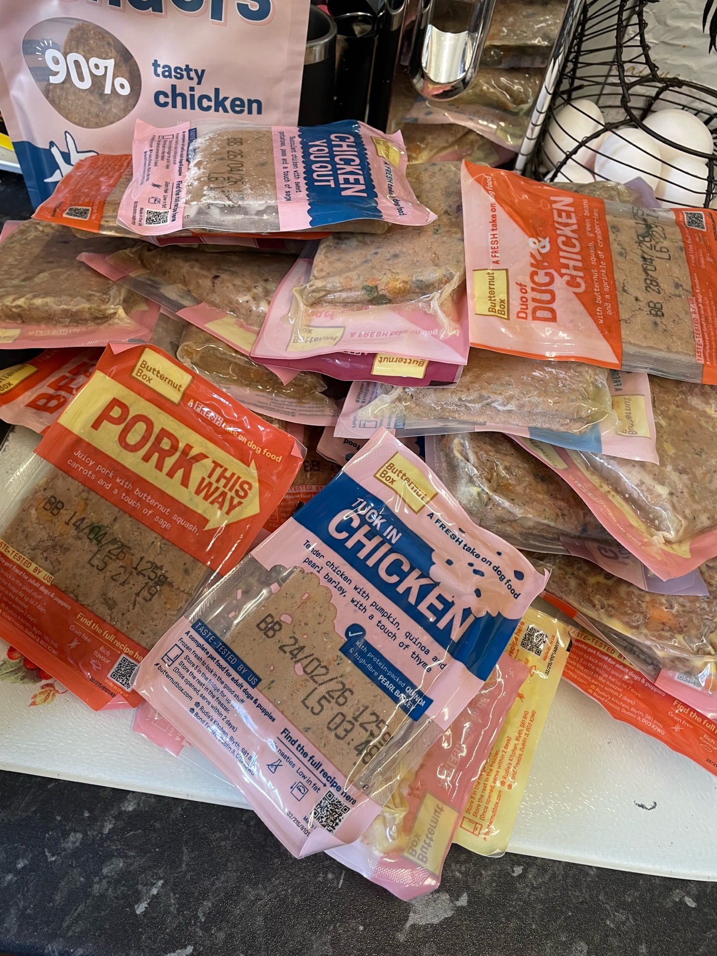 Pile of Butternut Box meal pouches: Pork This Way, Tuck In Chicken, Duck & Chicken and Chicken You Out.